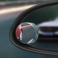 Close-up of round blind spot mirror showing reflected vehicles through glass