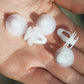 White plastic push clips with pin, shown in hand close-up