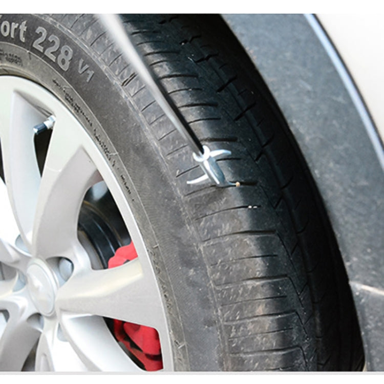 Metal hook inserted into car tire tread for cleaning between grooves