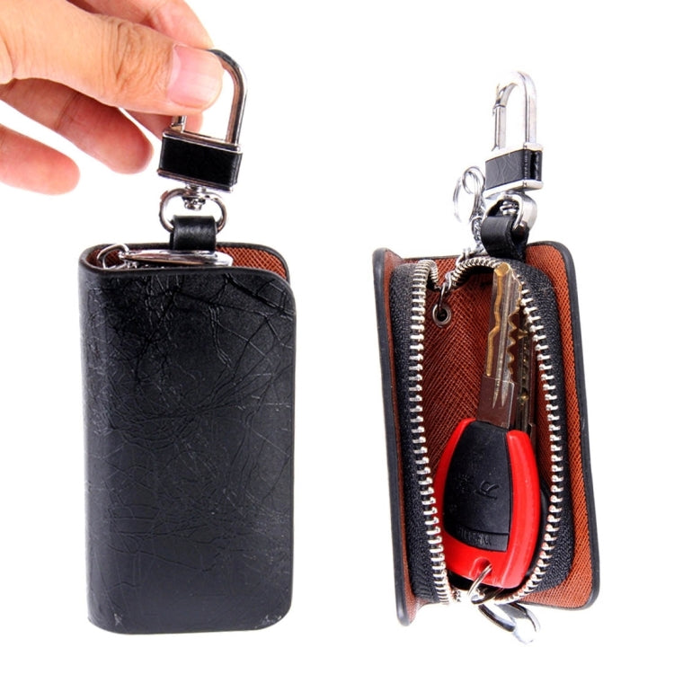 Black leather-texture key wallet with zipper, metal clip, and red interior detail