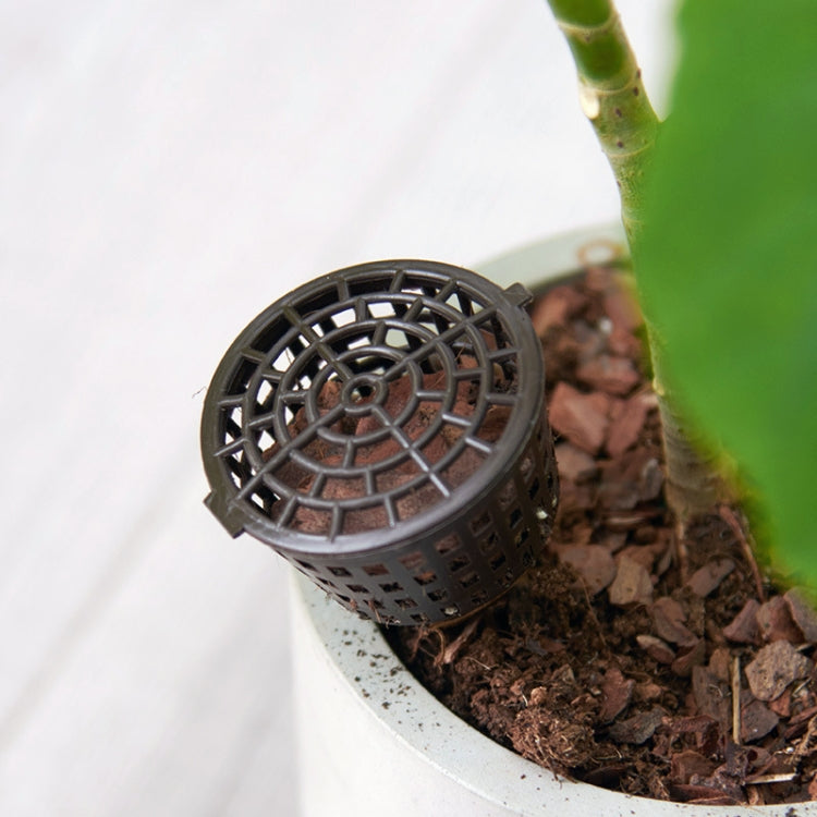 Round-top perforated dark bonsai fertilizer dispenser with cover in planter soil