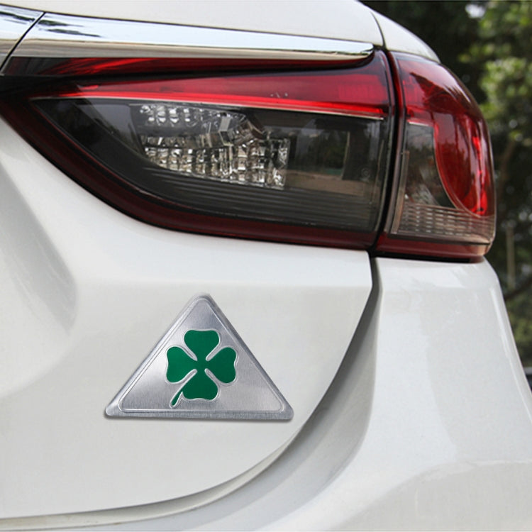Triangular aluminum clover badge on car rear panel