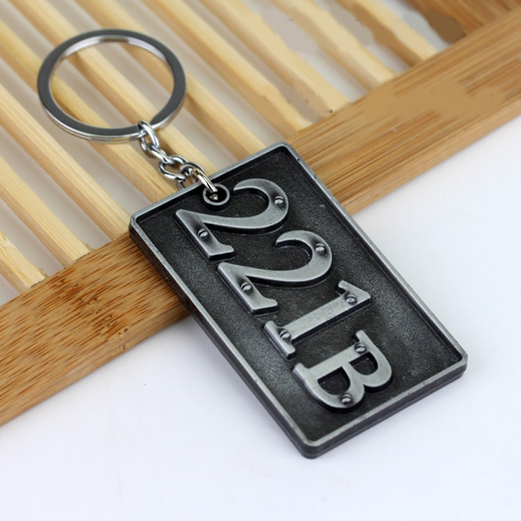 Metal keychain pendant with dark plate, 221B lettering, and linked split-ring chain