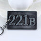 Metal keychain with large 221B lettering on dark rectangular plate