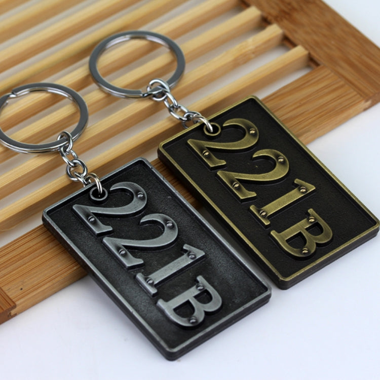 Two metal keychains with engraved plates, 221B and Sherlock-style letters, split rings