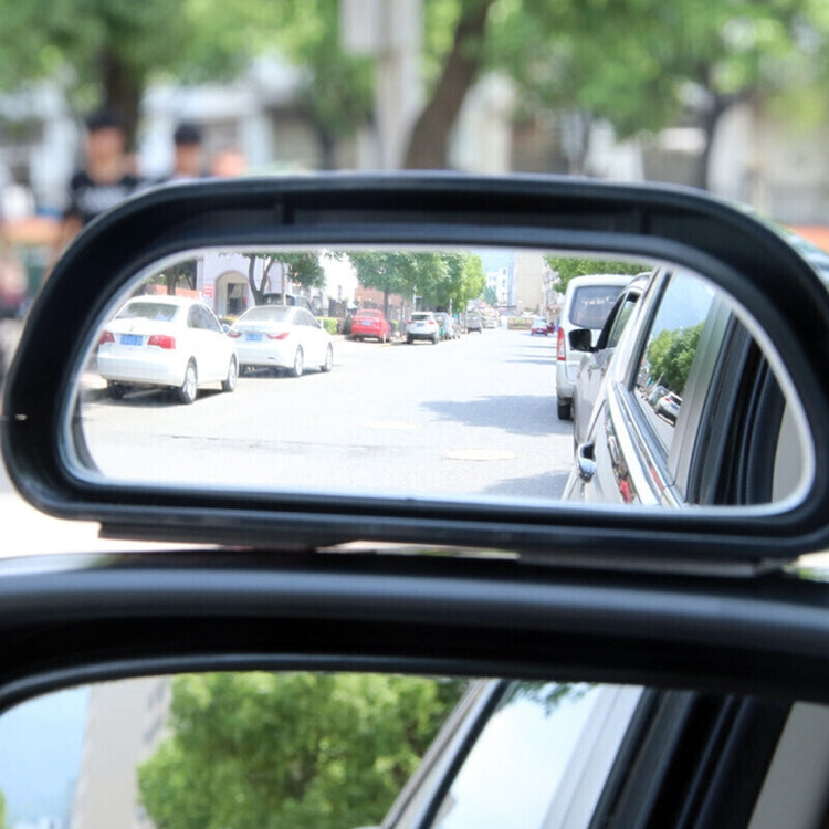 Close-up of wide-angle auxiliary side mirror reflecting street traffic