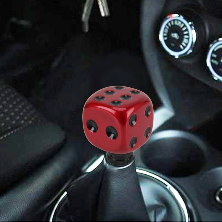 Red dice-shaped gear shift knob with black oval holes and textured base