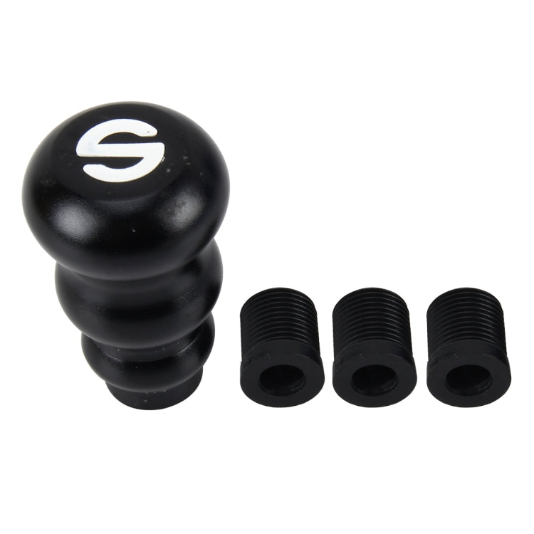 Black gourd-style gear shift knob with white shift emblem and three threaded adapter rings