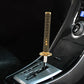 Gear shift knob with gold braided grip sleeve and chrome mounting base in console