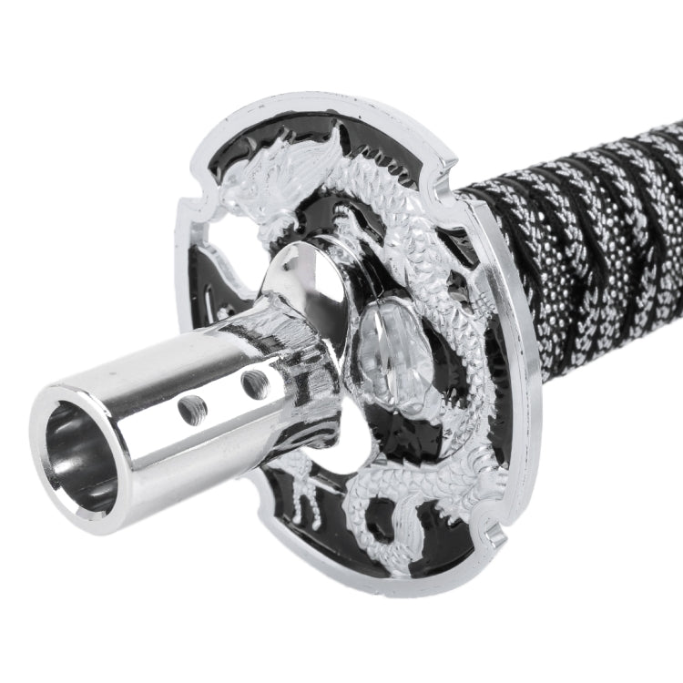 Gear shift knob close-up: chrome mounting plate with black braided sleeve