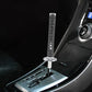 Universal gear shift knob with gold braided sleeve and chrome base in car interior