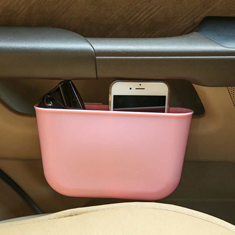 Pink portable car cup holder trash can bin holding a smartphone and eyeglasses