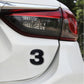 3D car number decal sticker with dark “3” on a white car panel