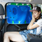 Blue car window sunshade cover with cartoon face print and grommets, installed on window