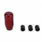 Red carbon-fiber style gear shift knob cover with three black mounting bolts.