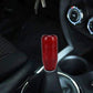 Red carbon-fiber style gear shift knob cover shown on a car shifter.
