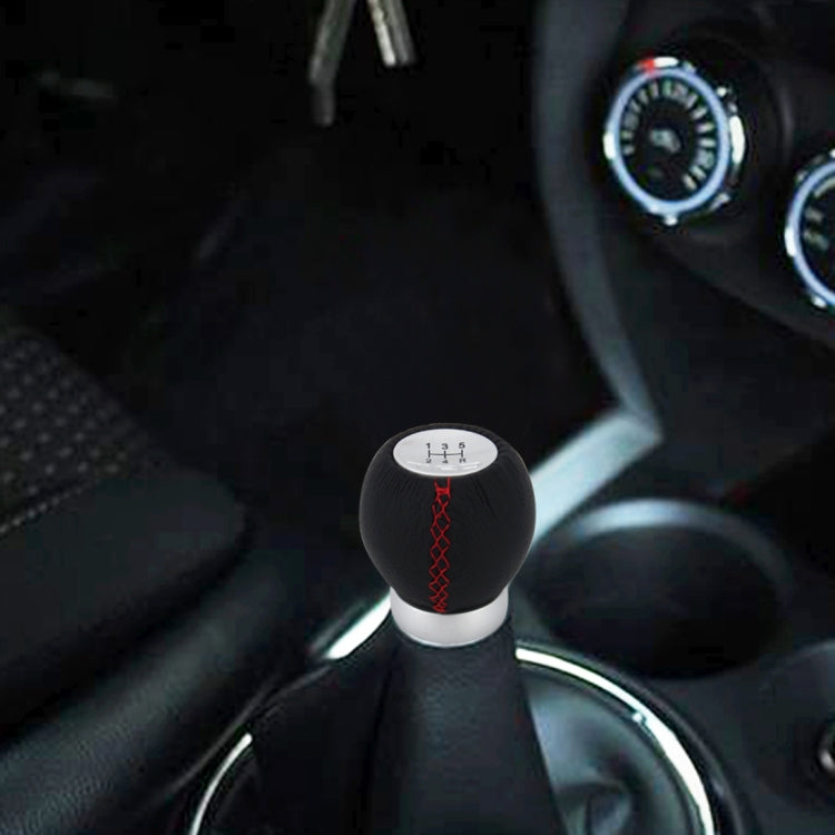 Black leather manual shift knob with red cross-stitch and silver base