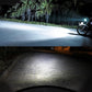 Motorcycle headlight beam illuminating road at night