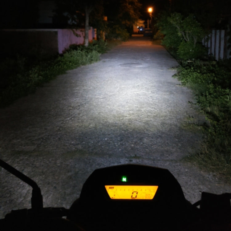 Motorcycle headlight beam shining on driveway path at night