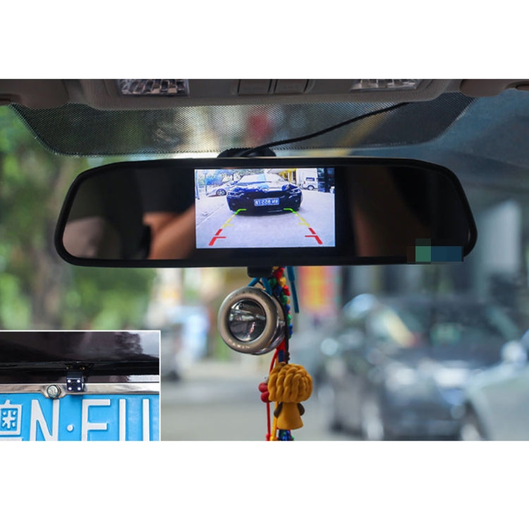 Rearview monitor close-up displaying reverse camera view with guide lines