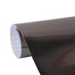 Metallic black vinyl decal roll, curved edge revealing white grid backing