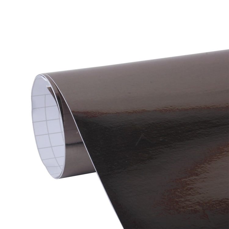 Metallic black vinyl decal roll, curved edge revealing white grid backing