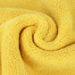 Microfiber cleaning towel fabric close-up, bright yellow fuzzy texture.