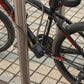 Bicycle-mounted blue vibration alarm with coiled sensor cable on frame