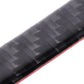 Close-up of black carbon fiber door edge guard with red trim strip along the edge.