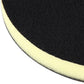 Close-up edge view of black grinding pad with yellow foam backing strip