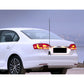 Car with long antenna aerial mounted at rear trunk, black-and-silver mast visible