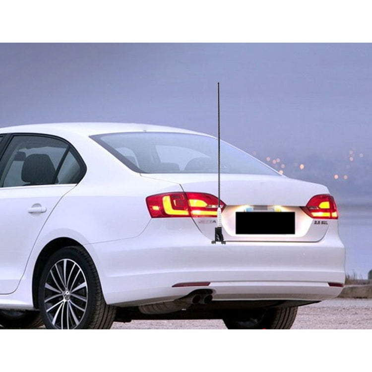 Car with long antenna aerial mounted at rear trunk, black-and-silver mast visible