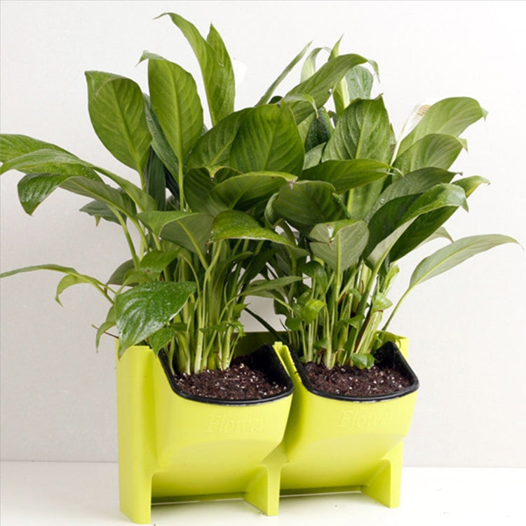 Lime green stackable wall planter with two black pots and leafy green plants