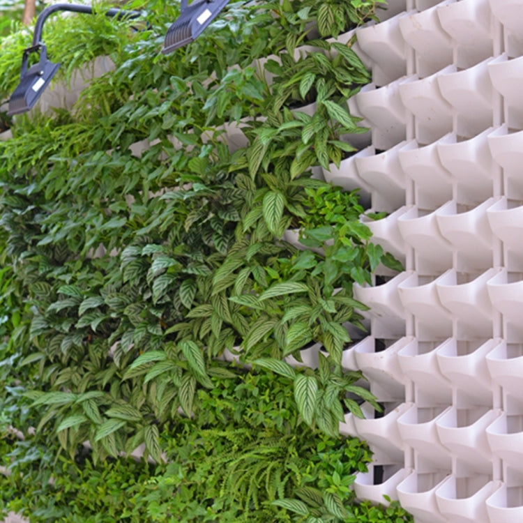 White stackable wall planter with open pockets holding green leafy plants