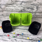 Lime green wall planter unit with two black pots filled with soil and plants