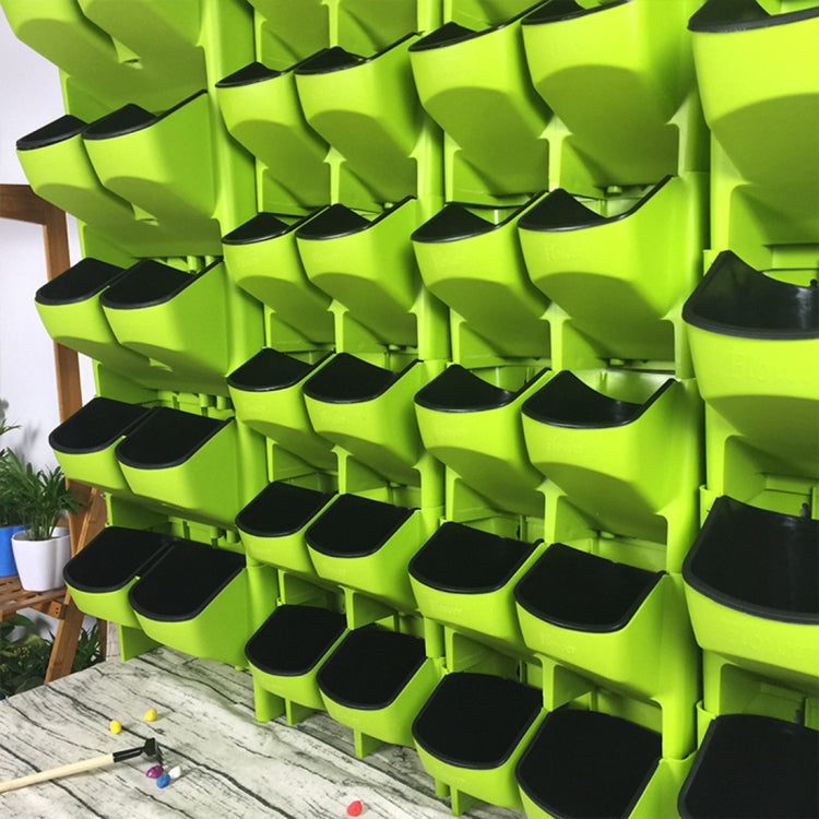 Close-up of lime green wall planter grid with many black pot openings