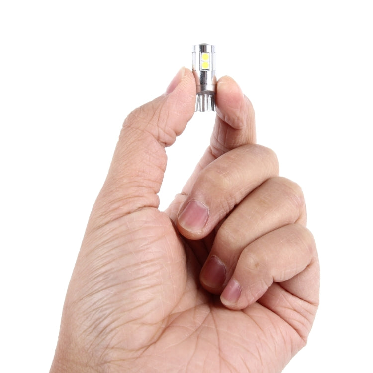 T10 LED bulb held in hand, chrome housing with visible yellow SMD chips