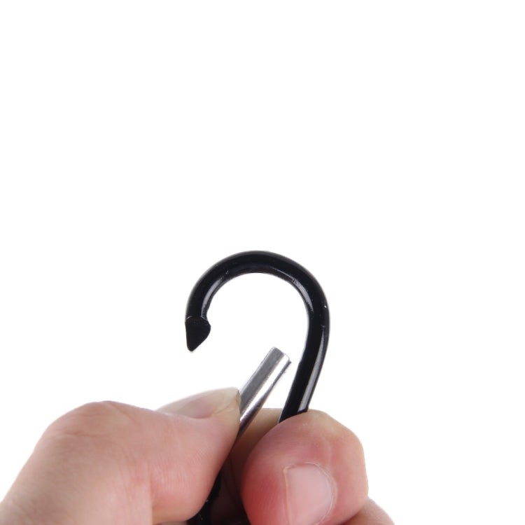 Hand holding black mini LED keychain flashlight with carabiner loop