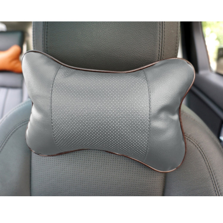 Light gray breathable leather car neck pillow with brown trim border and perforated center