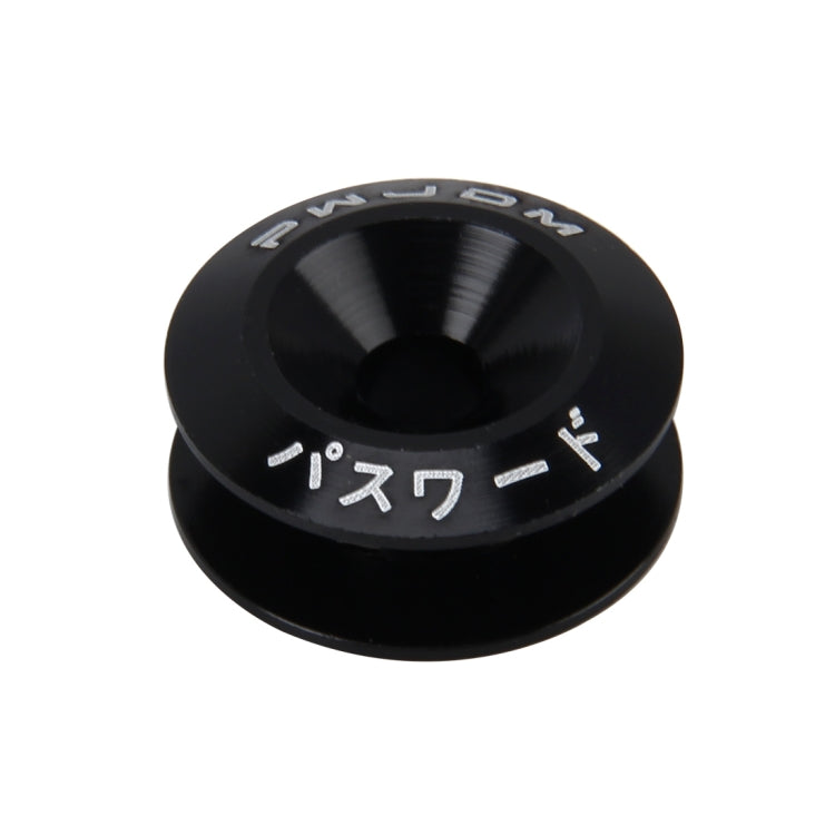 Black anodized bolt cap with raised center hole and embossed markings.