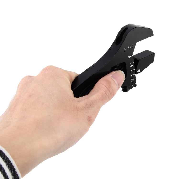 Adjustable spanner wrench held in hand, black adjustable head and scale