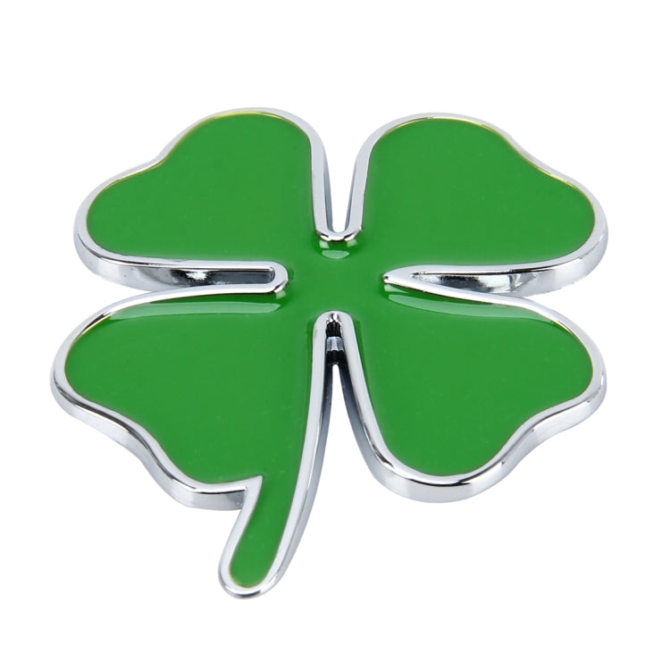 Four-leaf clover emblem sticker with green fill and shiny chrome border, close-up