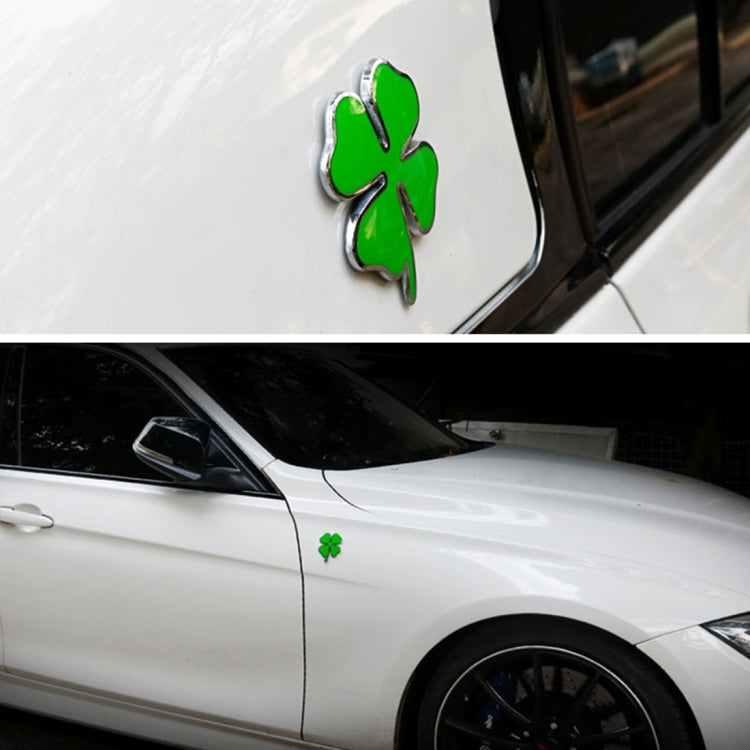 Four-leaf clover emblem sticker on white car body, green clover with chrome edge
