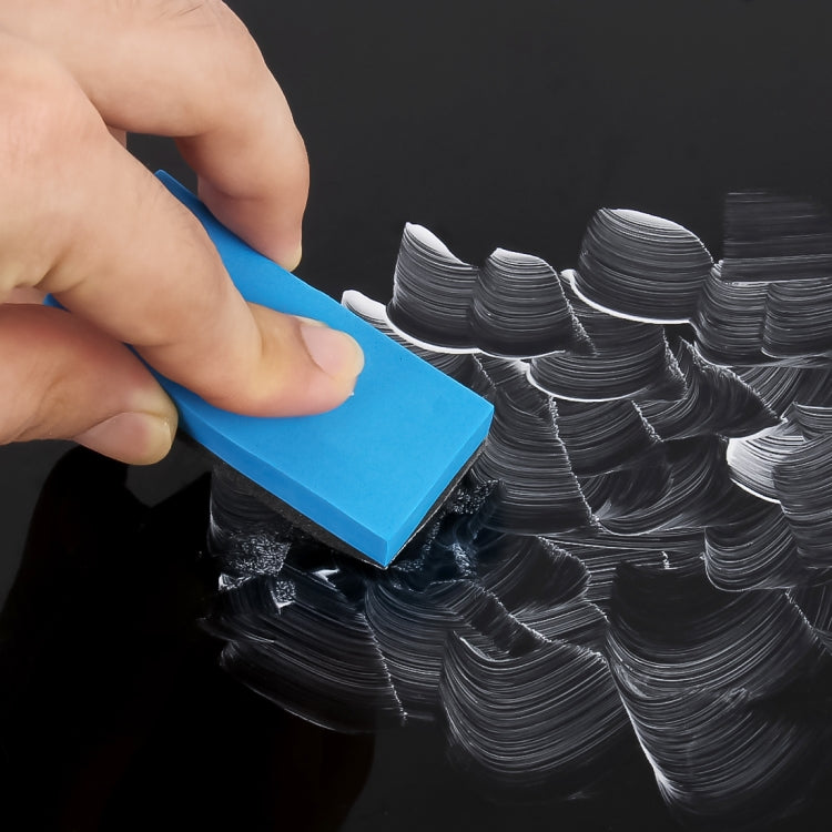 Blue polishing pad used by hand on a glossy surface with swirl marks