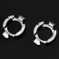 Two chrome metal circular retainer clips with cutout tabs, side view