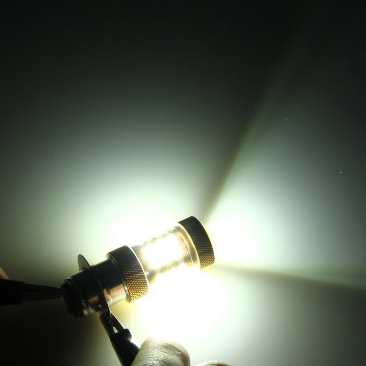 Bright white motorcycle LED headlight bulb glowing with silver base and gold textured ring