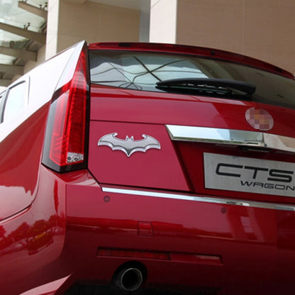 Metal bat car sticker with shiny silver bat design on the rear of a red car