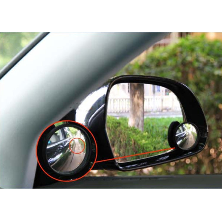 Black blind spot mirror mounted on a car door with a small round convex inset