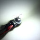 Car fog light LED bulb emitting bright white light in a dark setting
