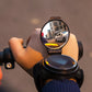 Black circular bicycle rear view wrist mirror with adjustable strap, shown worn on hand